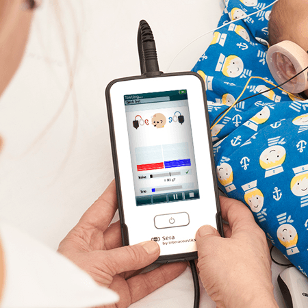 Person holding the Sera while performing hearing screening in sleeping baby