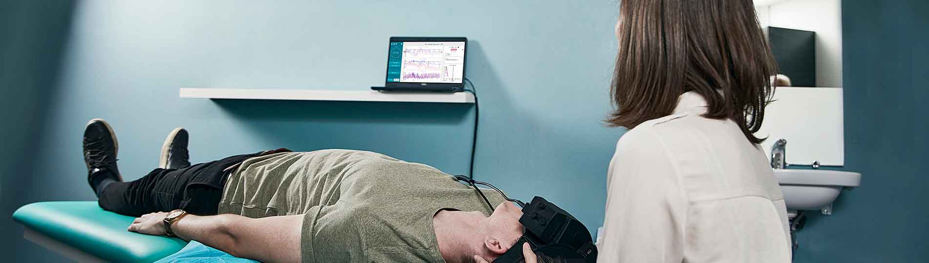 Female physical therapist performing advanced Dix-Hallpike test on male patient