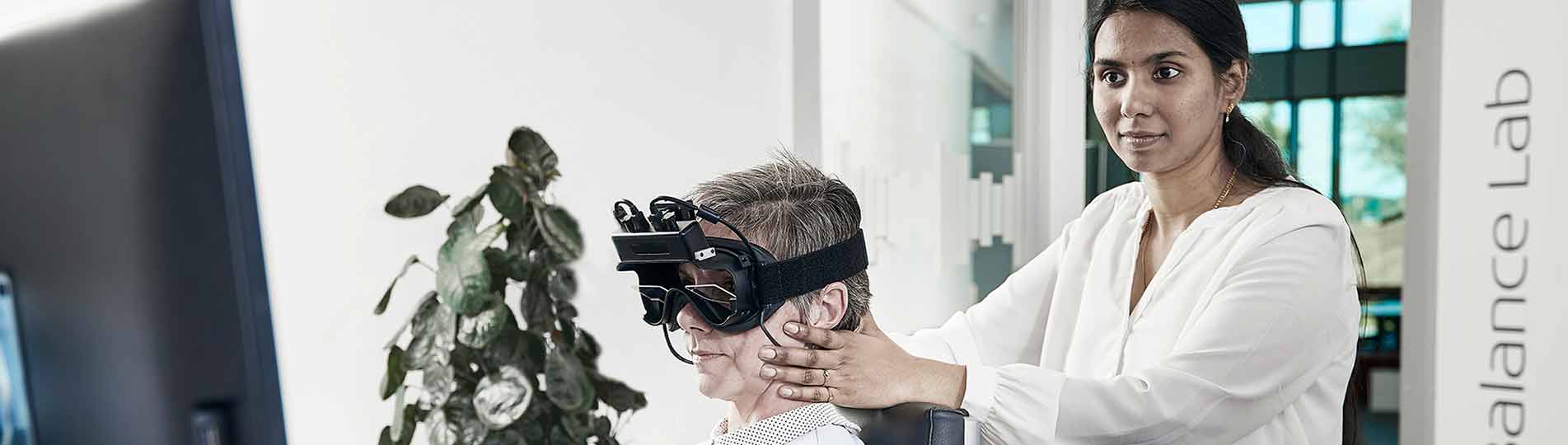 Female clinician performing oculomotor testing on female patient