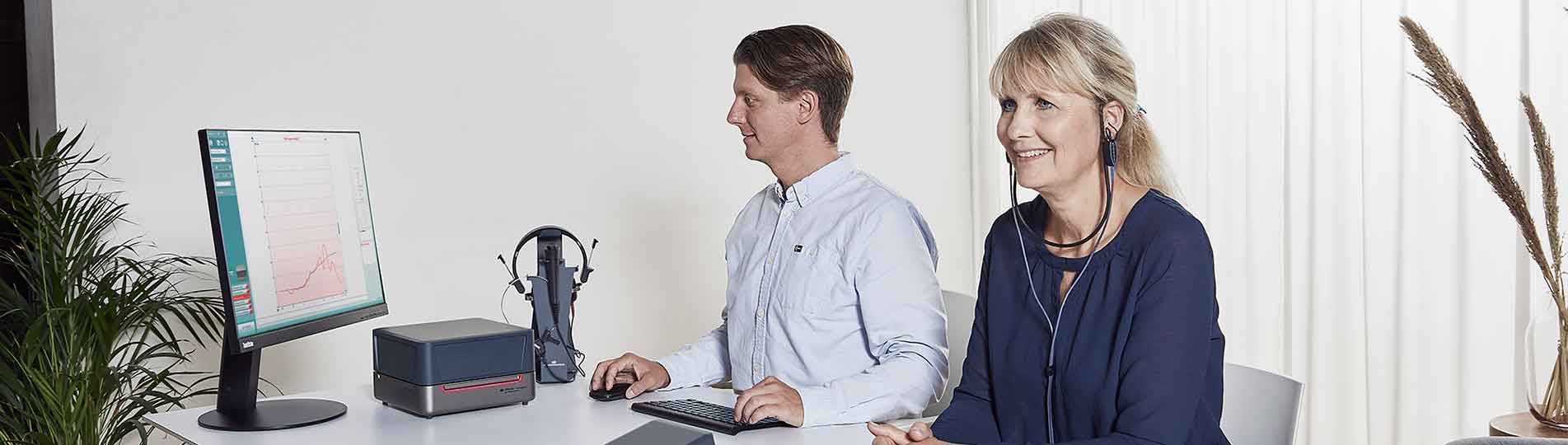 Male clinician performing real ear measurement in female client