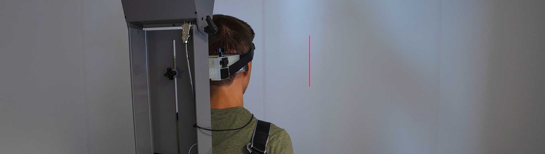 Male patient performing subjective visual vertical test in rotary chair